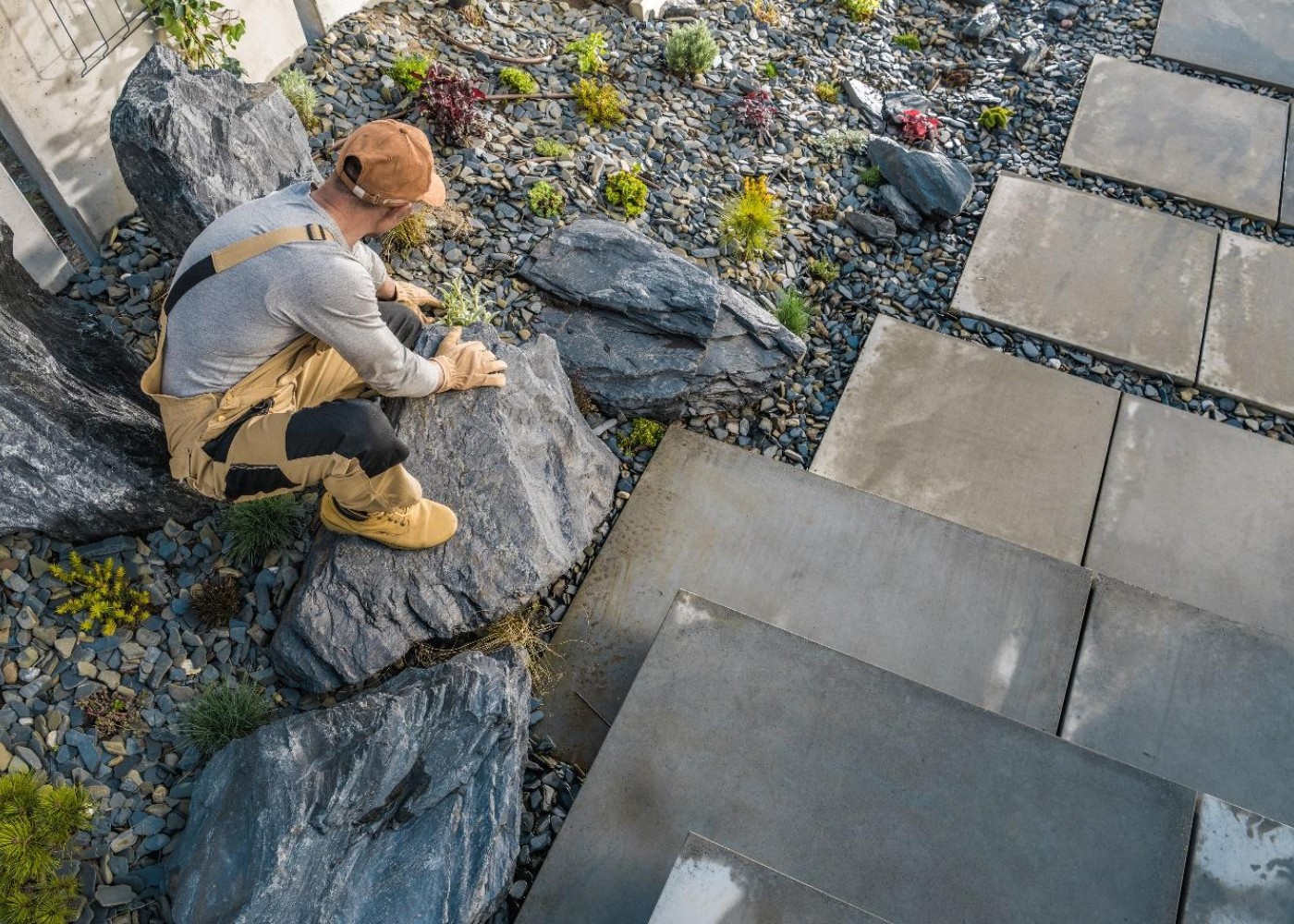 Skilled landscape designer arranging gravel in a modern backyard for a contemporary outdoor space.